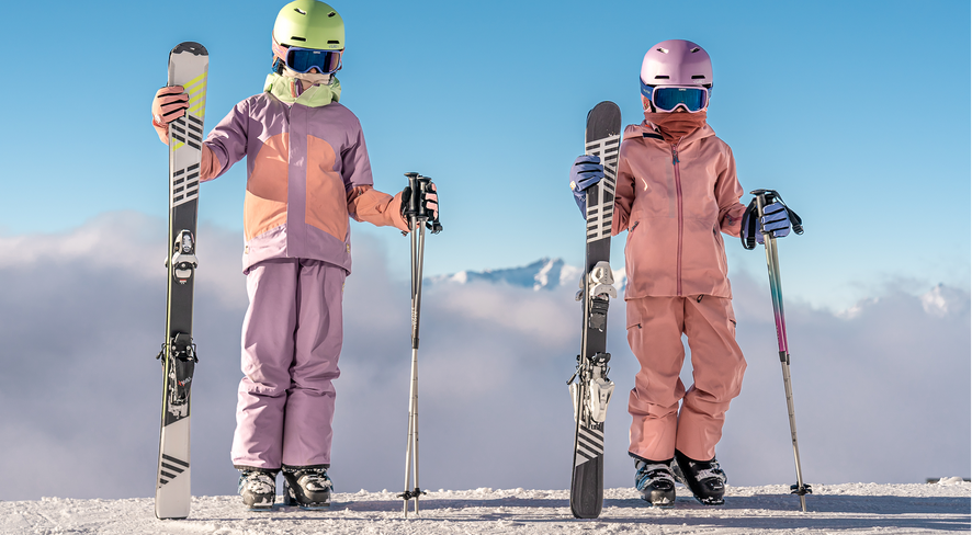 Zwei Kinder in Skikleidung auf dem Berg