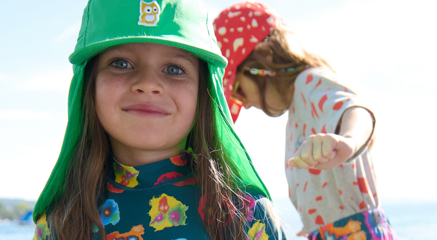 Mädchen in bunter Badekleidung blickt direkt in die Kamera