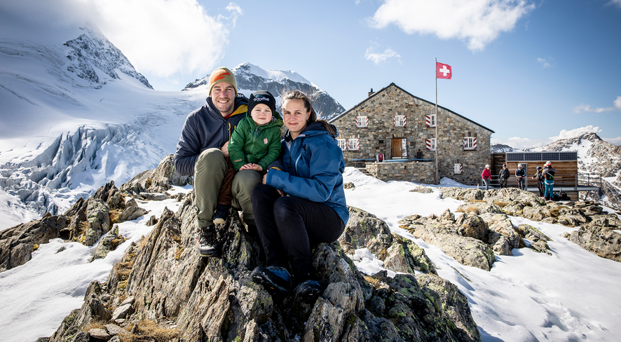 Familie sitzt auf einem Felsen vor der Tierberglihütte