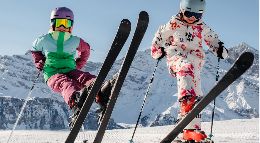 Zwei Kinder in namuk Skibekleidung stehen auf den Skiern