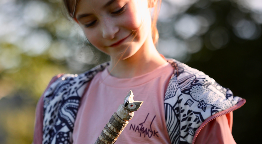 Mädchen in namuk Kleidung zeigt ihren selbstgeschnitzten Wanderstock