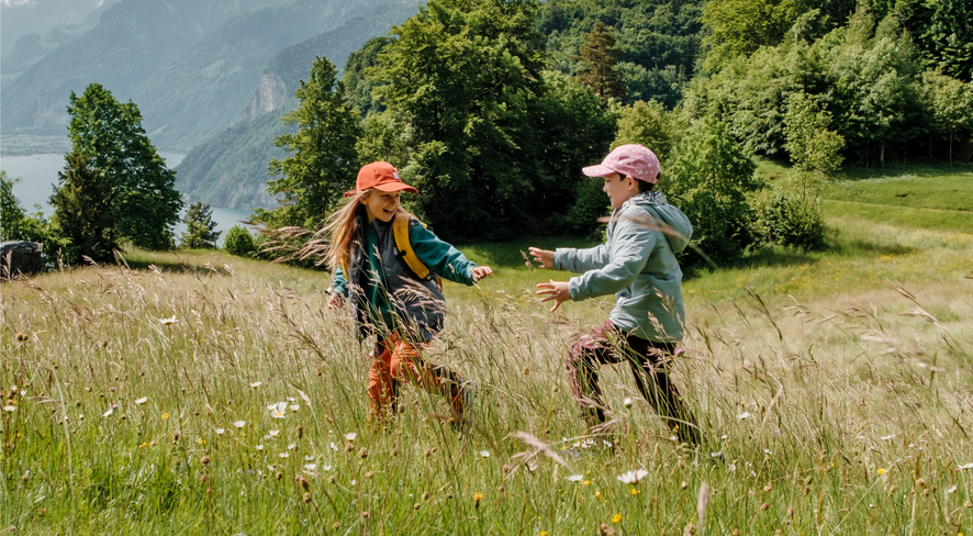 Kinder in namuk Primaloft Jacken rennen über die Wiese