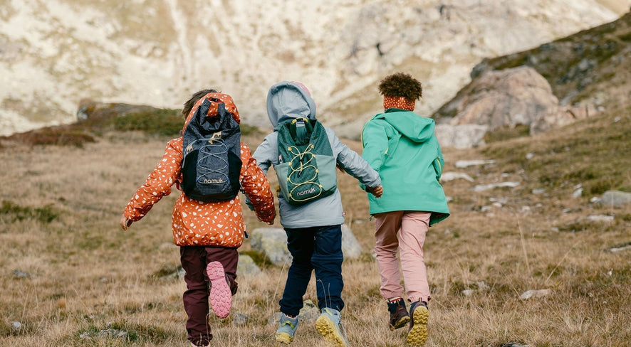 Kinder mit namuk Rucksäcken in der Natur