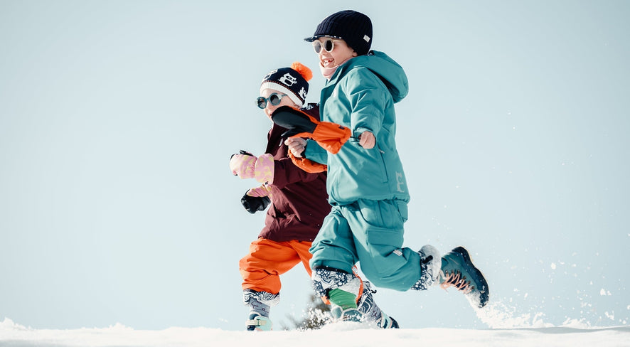Kinder in namuk Skikleidung rennen im Schnee