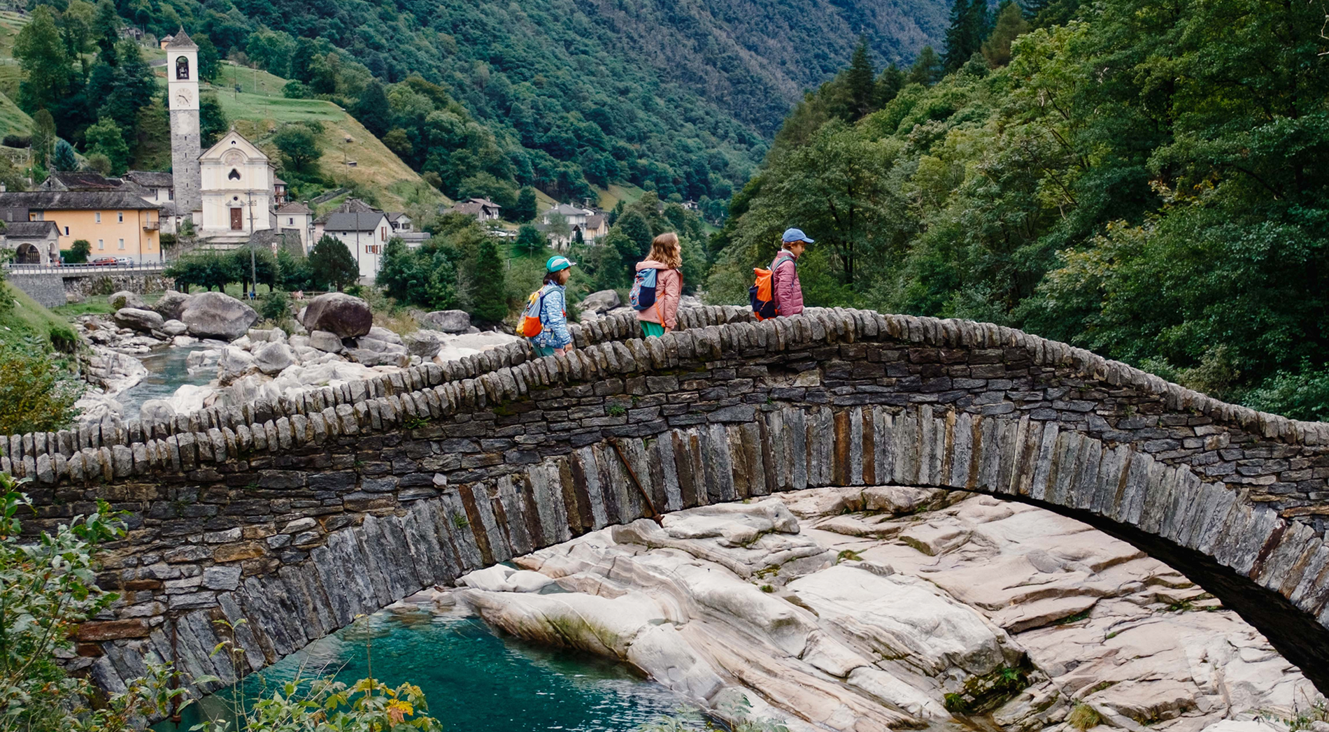 Kinder laufen über die Römerbrücke im Verzascatal