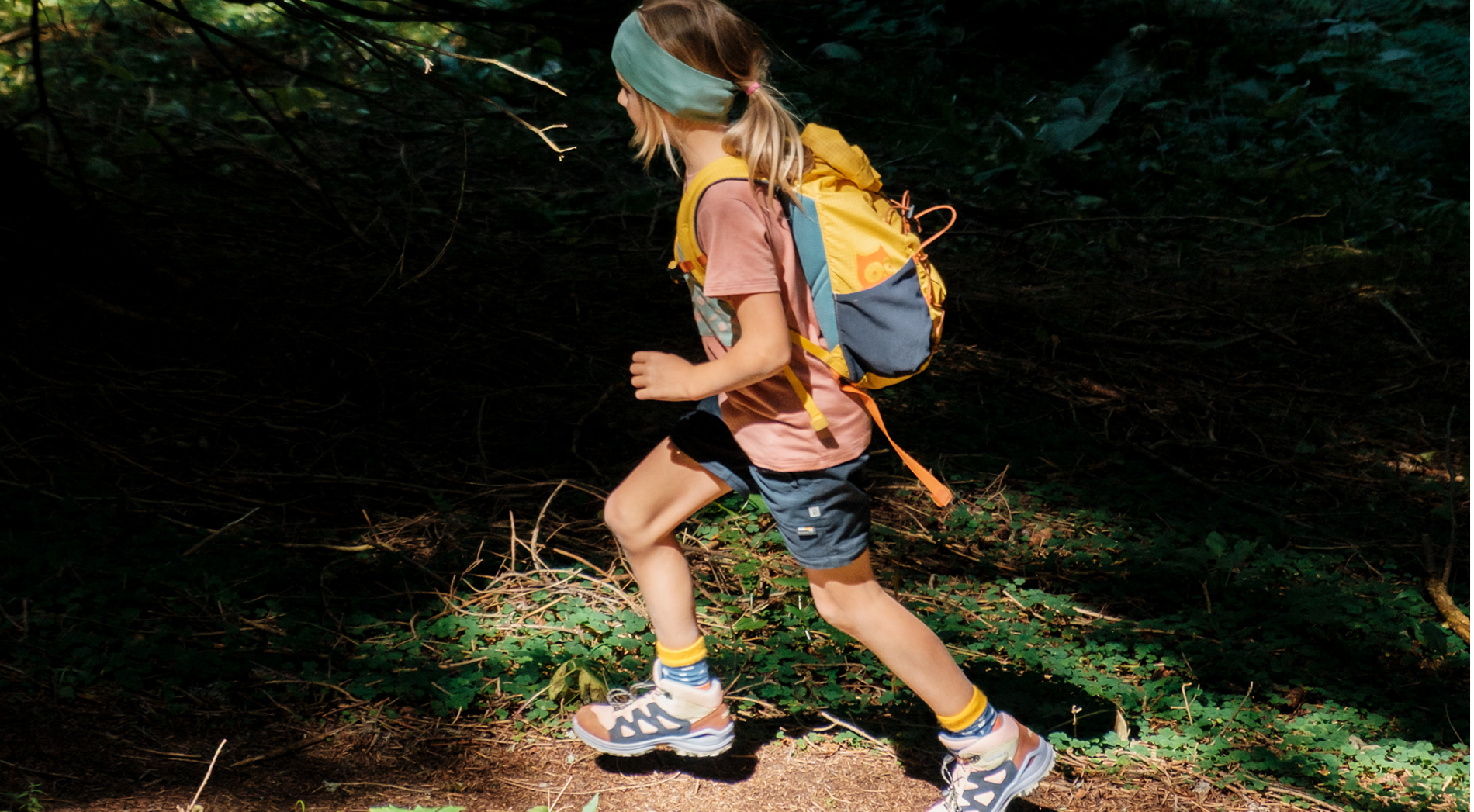 Wandern mit Kindern: Mädchen wandert in namuk Kleidung und mit namuk Rucksack durch den Wald