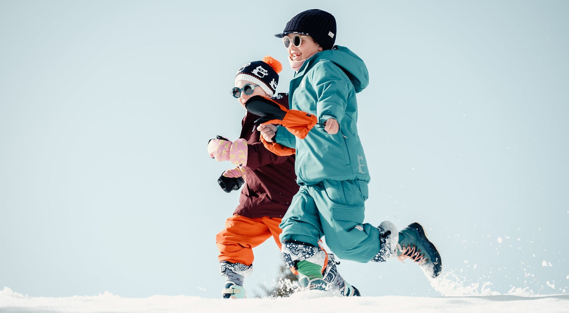 Zwei Kinder rennen durch den Schnee